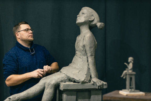 Man sculptor creates sculpt bust clay human woman sculpture. Statue craft creation workshop.
