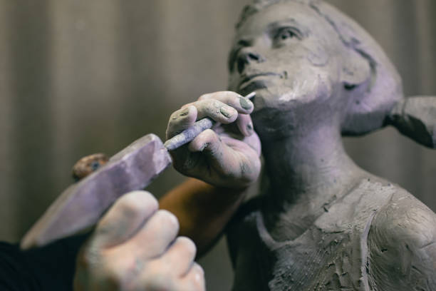 istock Man sculptor creates sculpt bust human woman sculpture. Statue craft creation workshop 1389975896