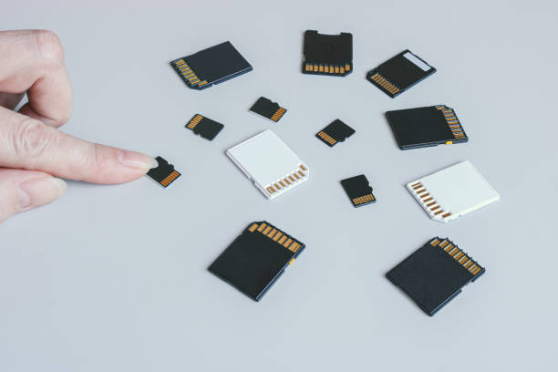 istock MicroSD memory card and hand on the background of other SD memory cards. 1389976451
