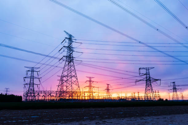 pylons, high voltage pylons in the evening - zest imagens e fotografias de stock