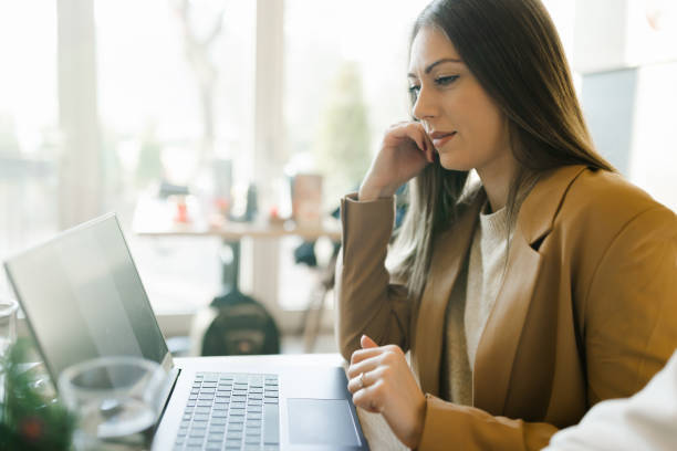 istock Beautiful young woman using laptop in cafe 1389979405