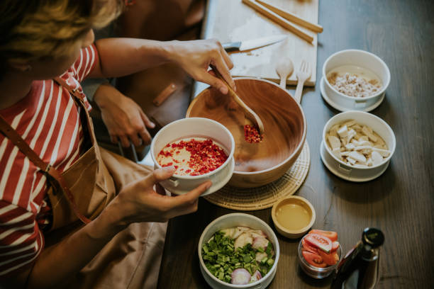 atividade de fim de semana do casal gay asiático cozinhando salada tailandesa para o almoço juntos. - thai culture thai cuisine spice ingredient - fotografias e filmes do acervo