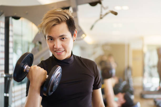 istock Strong sportsman doing a weight training using dumbbell. 1389991058