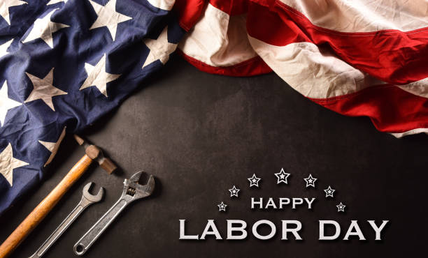 istock Happy Labor day concept. American flag with different construction tools and the text on dark stone background. 1389994689