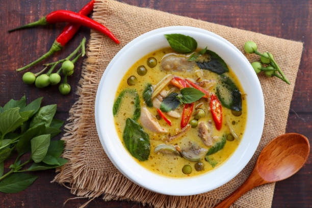 istock Thai Green curry with chicken - Thai authentic food called  Kang Kiew Wan with some ingredients at top view on wood table 1389996270
