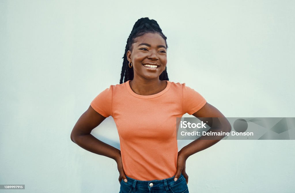 Shot of an attractive young women posing against a blue wall outdoors Rock your realness Women Stock Photo