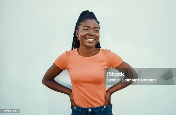 Shot Of An Attractive Young Women Posing Against A Blue Wall Outdoors Stock Photo - Download Image Now