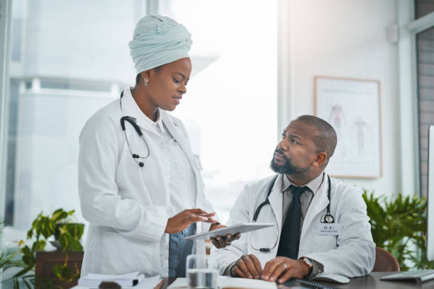 istock Shot of two doctors using a digital tablet while having a discussion in a modern hospital 1390000444