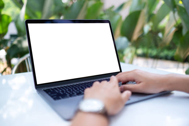 istock Mockup image of a woman using and typing on laptop computer with blank white desktop screen 1390001844