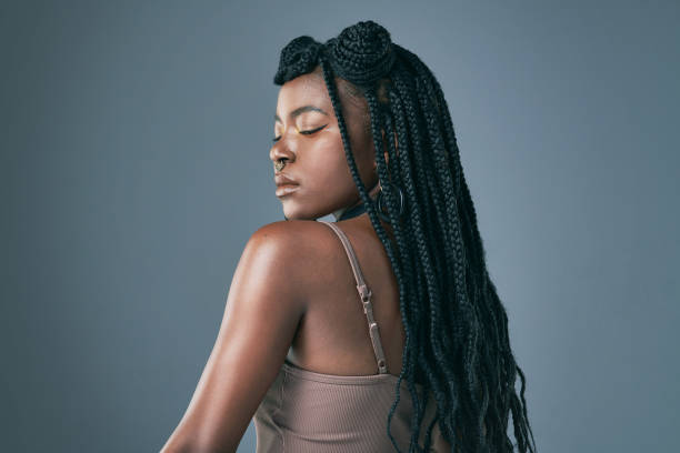 foto de estudio de una joven de moda posando sobre un fondo gris - trenzas fotografías e imágenes de stock