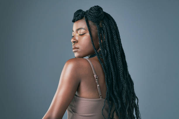 Studio shot of a trendy young woman posing against a grey background I've got my own back braided hair stock pictures, royalty-free photos & images