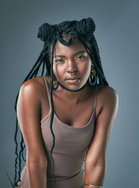 scatto in studio di una giovane donna alla moda in posa su uno sfondo grigio - pierced human hair black fashion model foto e immagini stock
