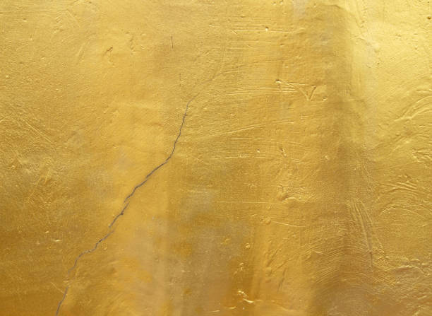 istock Gold plastered concrete wall with cracks, background 1390010494