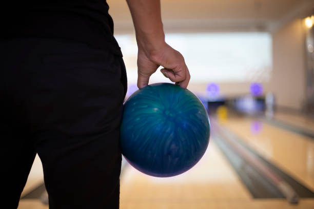 Back side a man standing holding a bowling ball with copy space stock photo
