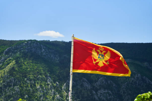 the flag of montenegro develops in the wind. view from the kotor fortress - karadağ bayrağı stok fotoğraflar ve resimler