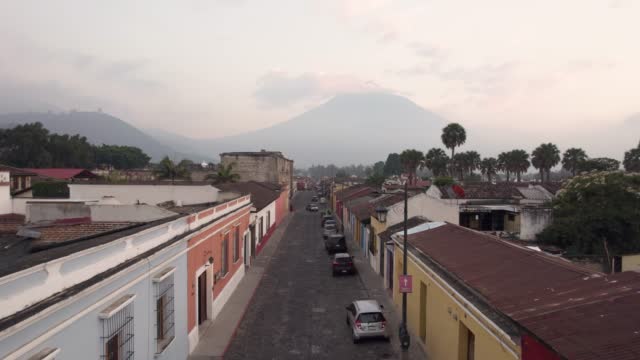 View of the inactive Agua volcano, cobblestone streets and rooftops in Antigua Guatemala on a cloudy day