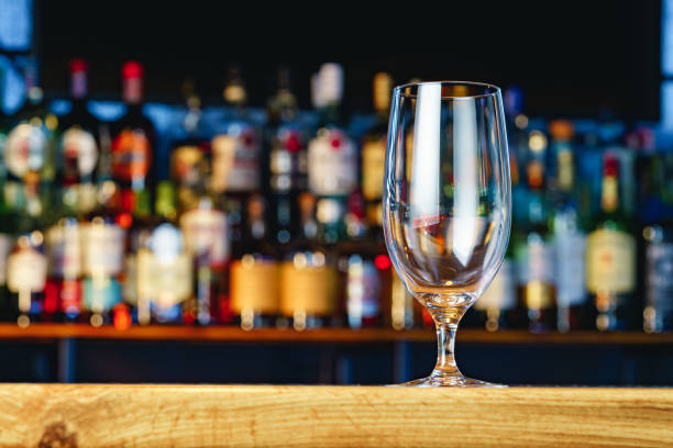 istock Empty beer glass on a wooden bar counter 1390014675