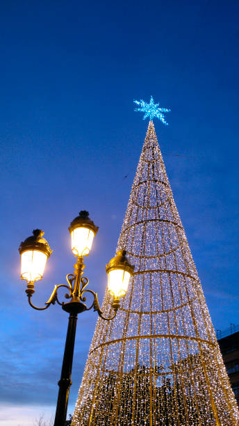 istock Modern lighting Christmas tree at dusk, townsquare,   old-fashioned street light , 1390016005