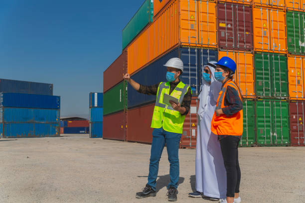 istock Middle Eastern Businessman and engineers with face mask working outside on a large commercial dock during pandemic. 1390017276