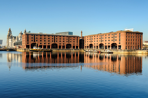 Liverpool, England - Royal Albert Docks on the clear blue day. The Royal Albert Dock is an area of dock buildings and warehouses. Designed by Jesse Hartley and Philip Hardwick, it was opened in 1846.