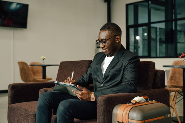 businessman uses tablet waiting for a flight. - gate imagens e fotografias de stock