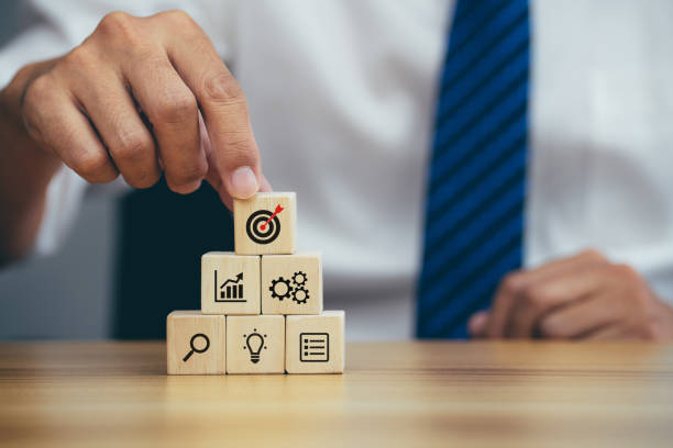 istock Businessman stack woods block step on table with icon business strategy and action plan 1390019329