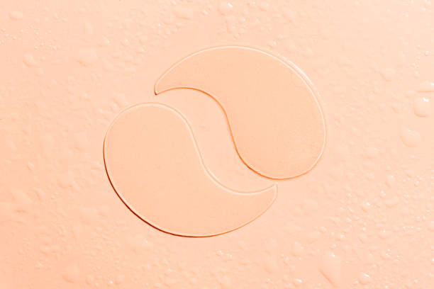 Hydrogel nude eye patches Hydrogel nude eye patches on light skin tone background with water drops close up. Cosmetic moisturizing hydrating under eye patches with collagen. one eyed stock pictures, royalty-free photos & images