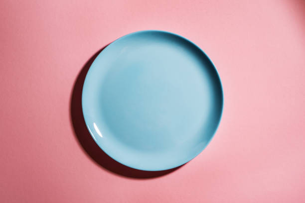 Blue empty plate on pink background stock photo