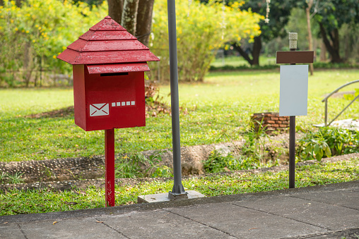 Red wooden mailbox with garden path