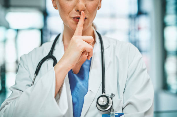 Shot of a doctor with her finger on her lips in a modern hospital stock photo