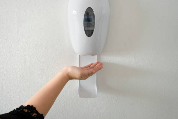 istock woman's hand using alcohol gel with automatic machine in the hospital for cleaning hands. Economical and clean infection prevention concept in the state medical center area. disinfection 1390024917