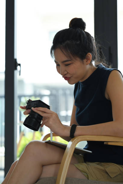 istock Female freelancer setting and checking picture previews on her camera. 1390024941