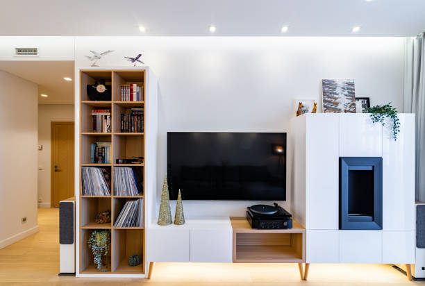 View to living room entertainment center area. Wide screen TV, stereo, turntable, bookshelf, fire place.