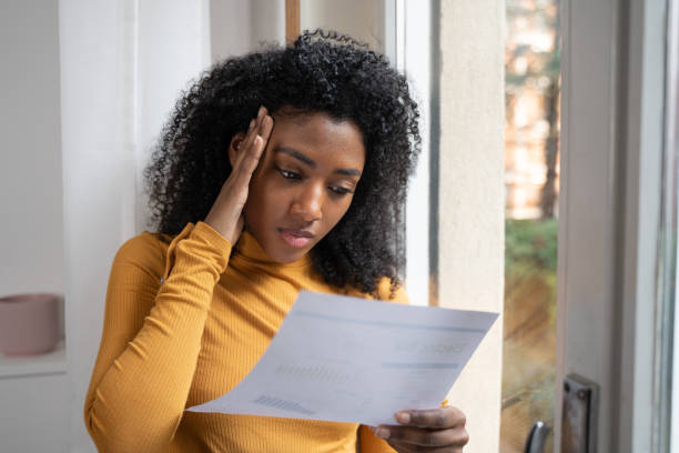 istock Black woman reading a bill and feeling sad 1390032717