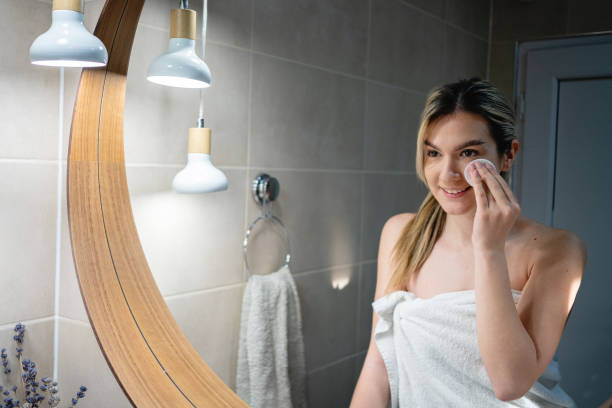 istock Caucasian woman removing her make up, while observing herself in the mirror 1390034159