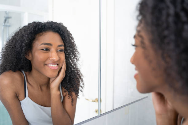 istock One black woman looking skincare mirror 1390034774