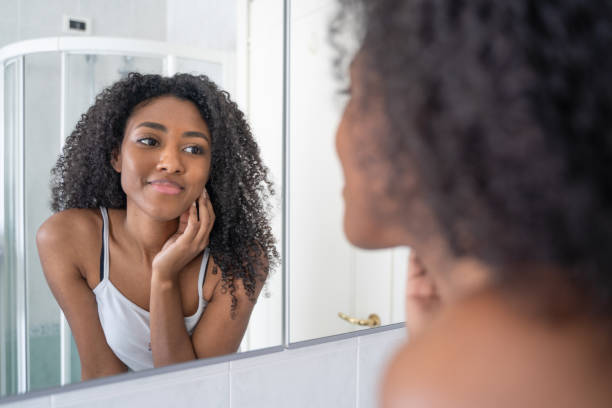 istock One black woman looking skincare mirror 1390034896