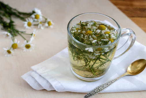 Medicinal chamomile is a valuable herbal medicinal raw material. Next in a Cup of herbal tea with chamomile infusion.