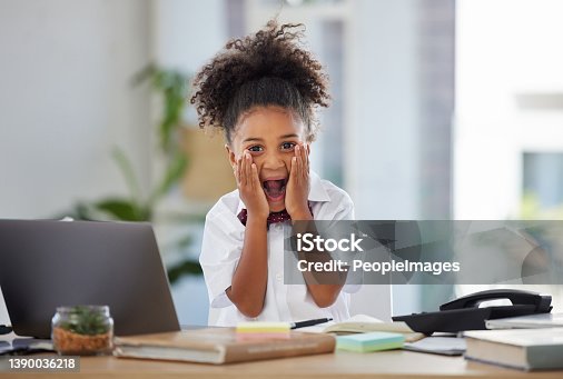 istock Shot of an adorable little girl dressed as a businessperson sitting alone in an office and looking surprised 1390036218