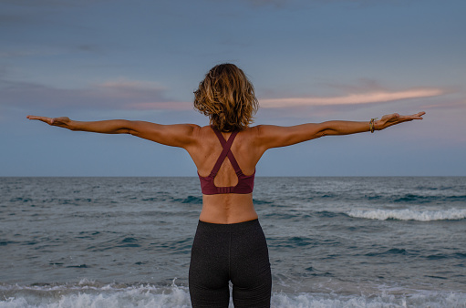 Mujer haciendo yoga cerca del mar photo
