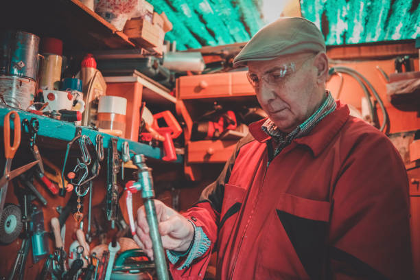 istock Retired metalworker looking at piece of leaking pipe 1390037994