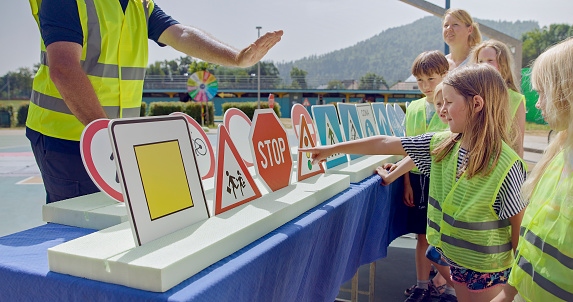 Children looking in front of a row of traffic signs and learning their meaning
