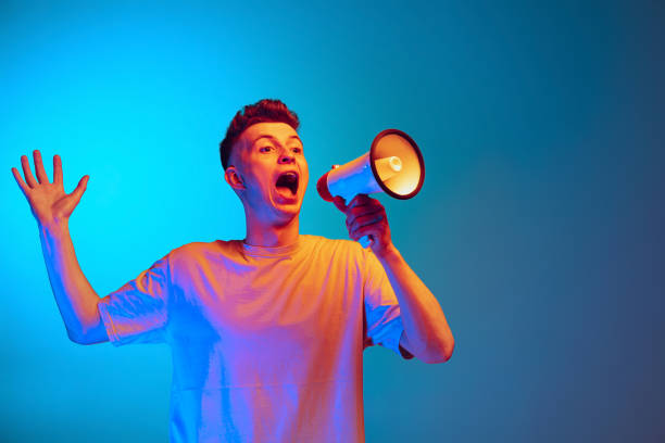 istock Studio shot of young emotional man, student posing isolated over blue studio background. Action, sport, fashion, sales and news 1390040132