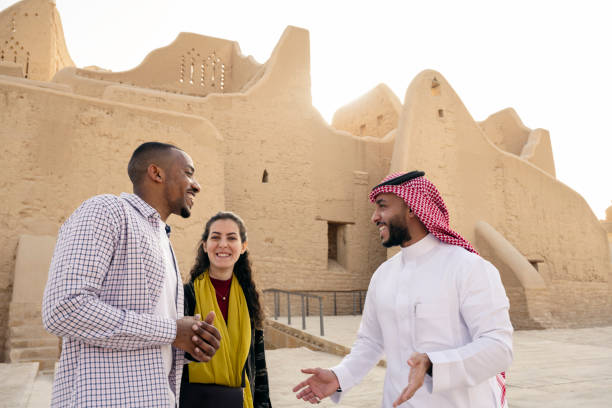 Cheerful Saudi guide talking with tourists at Salwa Palace