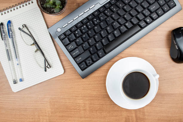 istock Coffee at workplace, top view of work desk with keyboard and stationery, space for text 1390041301