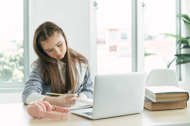 istock Girl student online learning class with laptop computer and book at home 1390041808