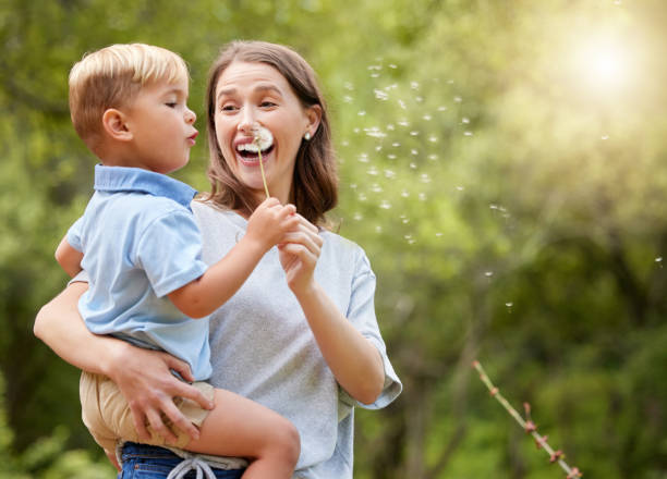 Shot of a young mother and son spending time together in nature Blow it all away flower outdoors day loving stock pictures, royalty-free photos & images