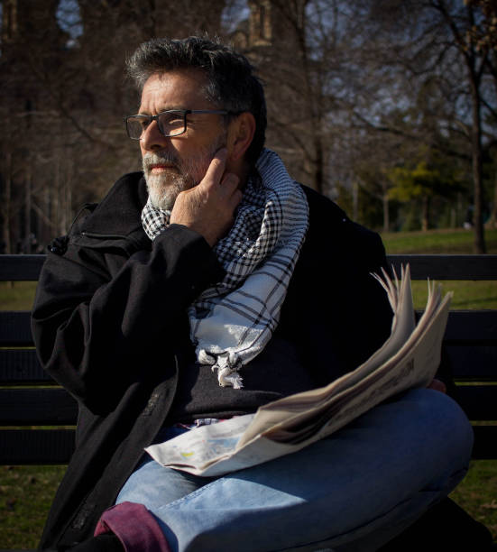 istock Senior bearded man with glasses read newspaper 1390043136