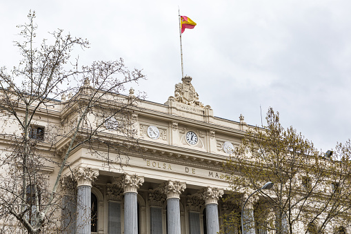 Facade of the Madrid Stock Exchange, Spain, with a sign that says: 'Stock Exchange of Madrid'. Concept Stock market, trading, investment, broker and tourism concept.