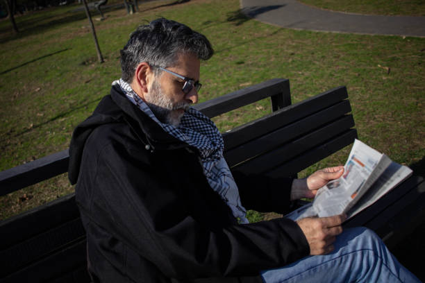 istock Senior bearded man with glasses read newspaper 1390043145